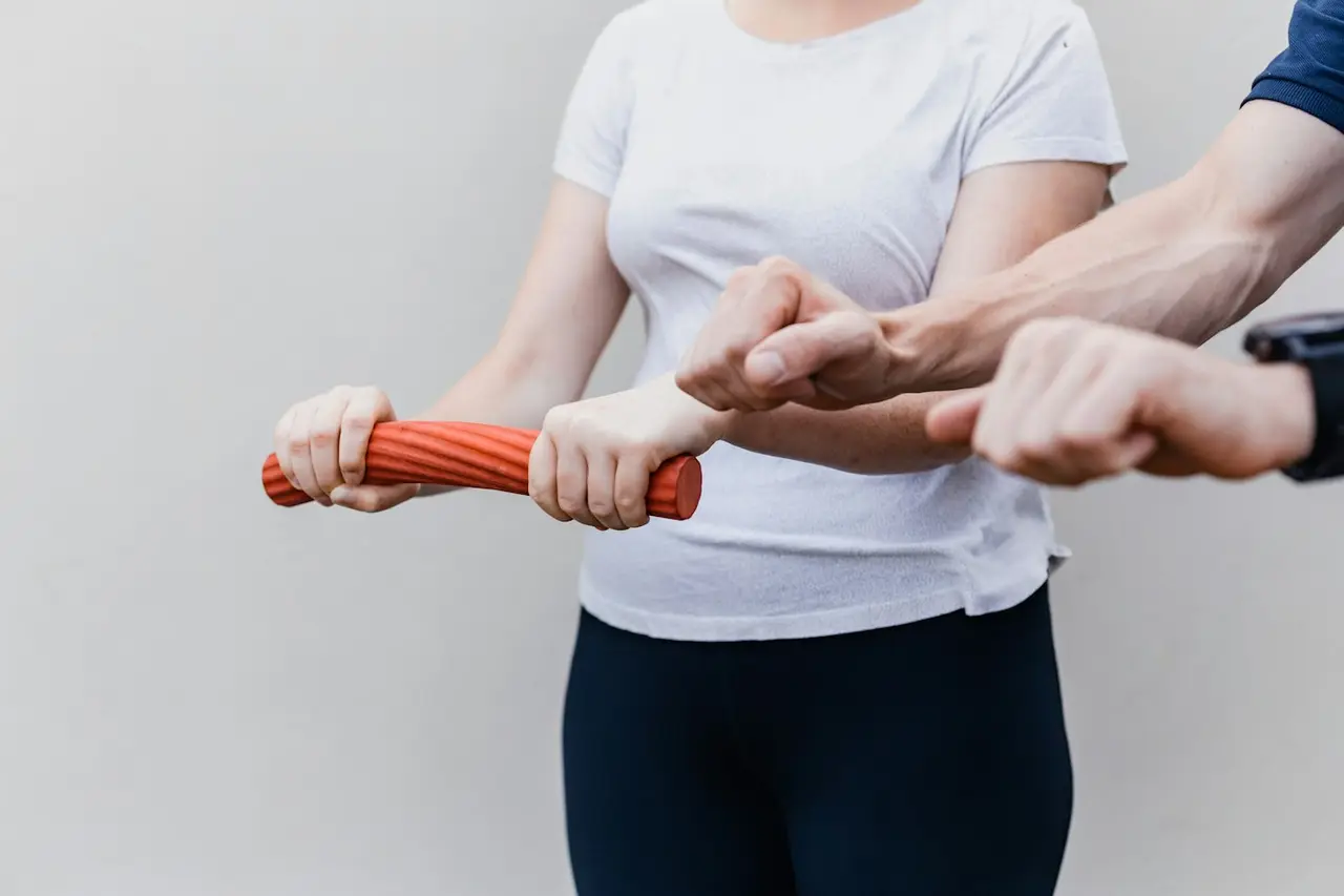 A patient working with a resistance band beside a therapist