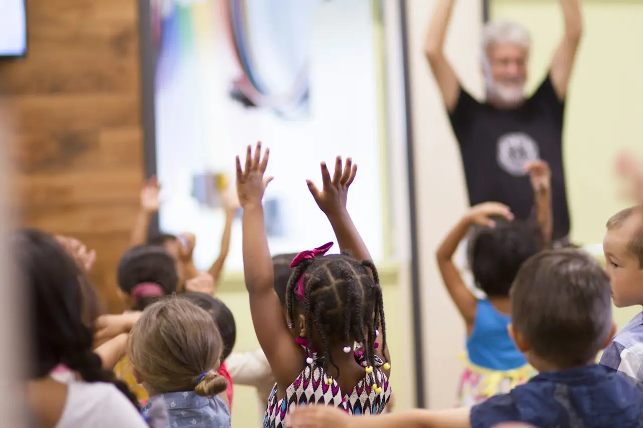 Children lifting their hands in a kids program