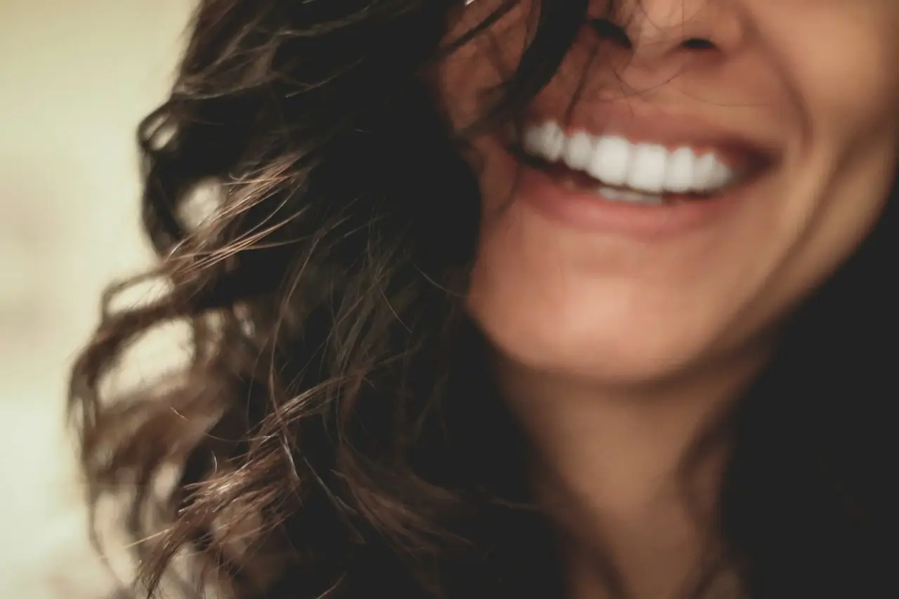 A close-up of a woman laughing with a bright smile