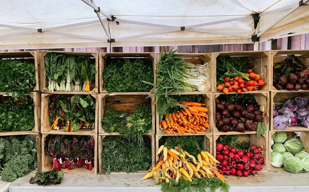 Vegetables displayed in wooden crates at a stand