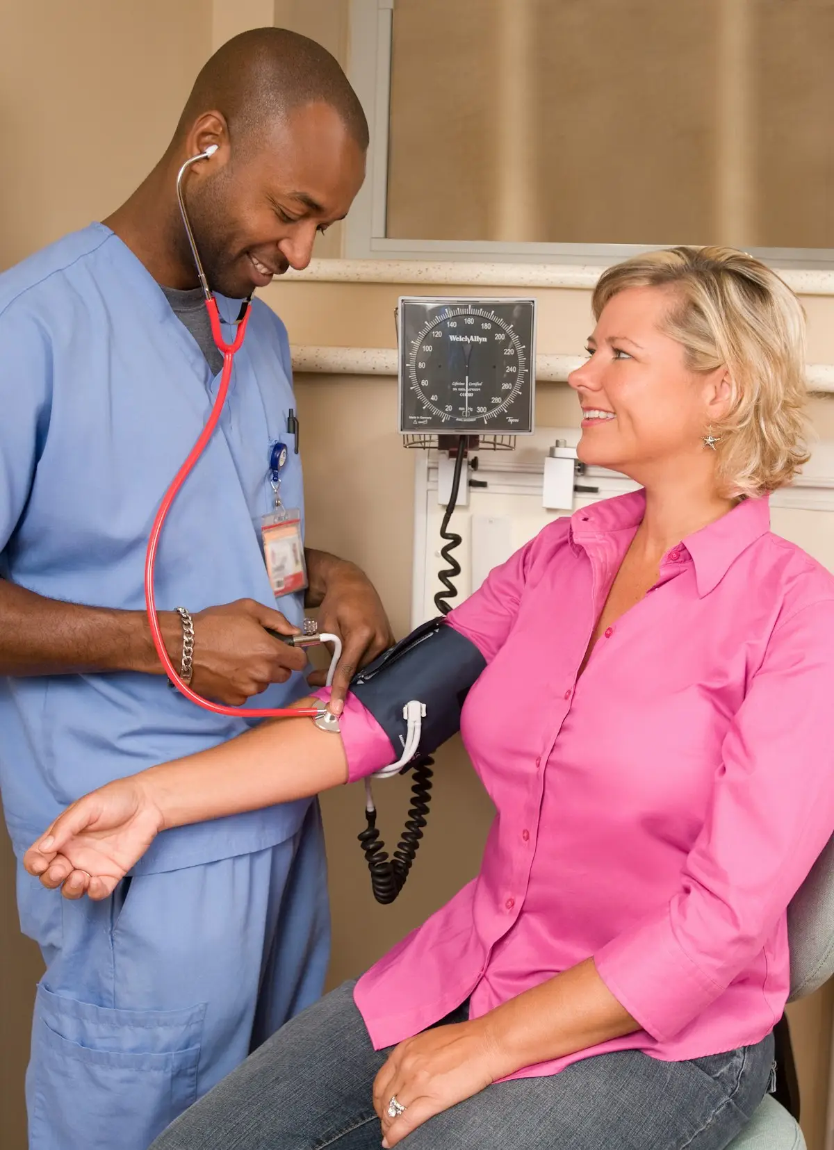 A nurse in scrubs taking a patient's blood pressure