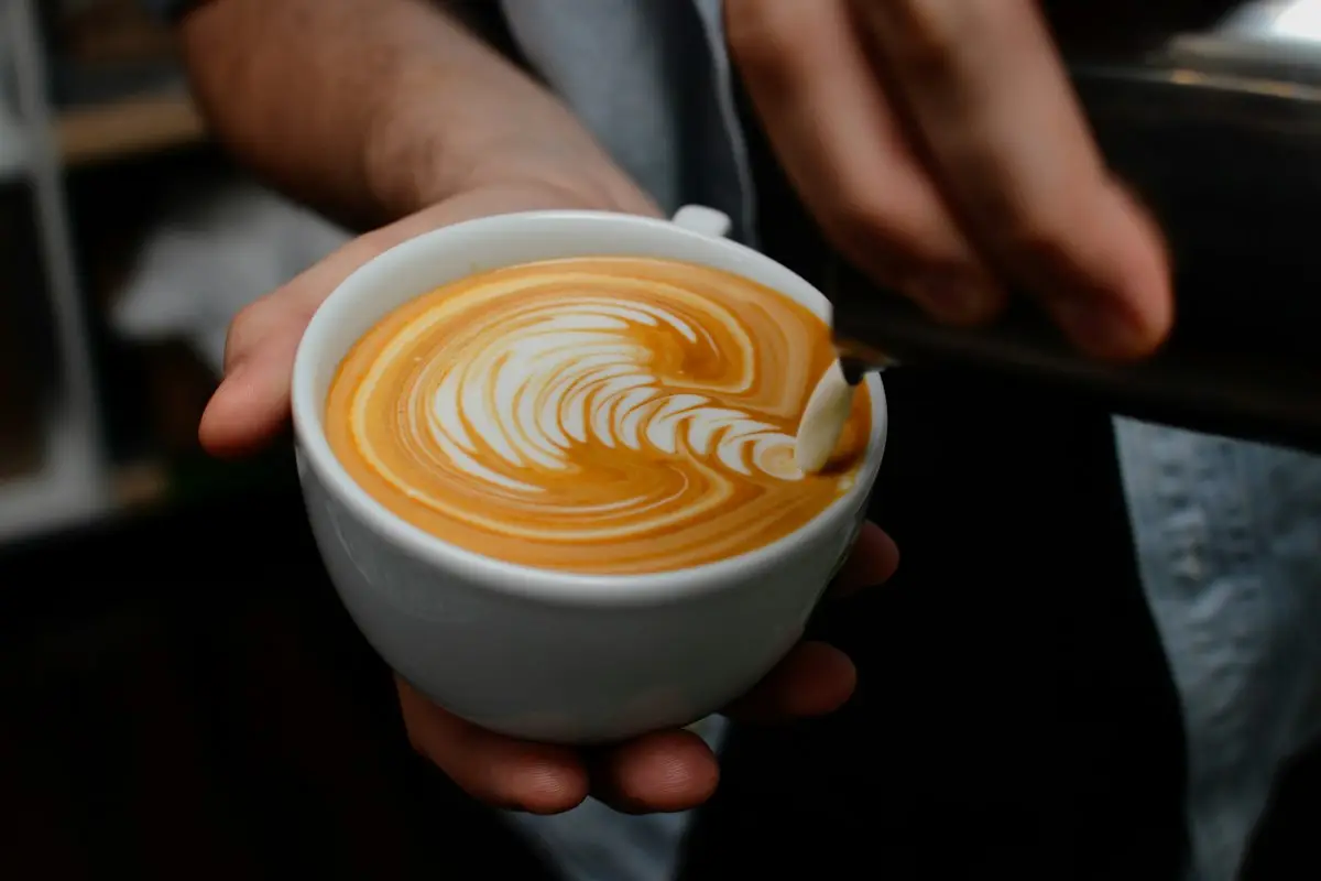 A barista pouring latte art