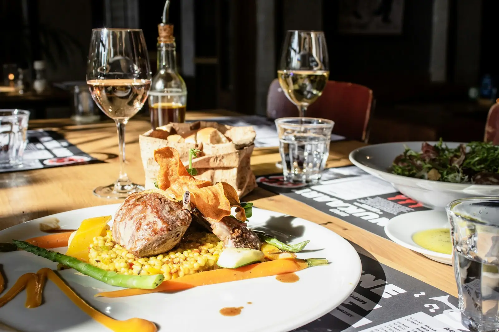 A table set with plates, wine and bread