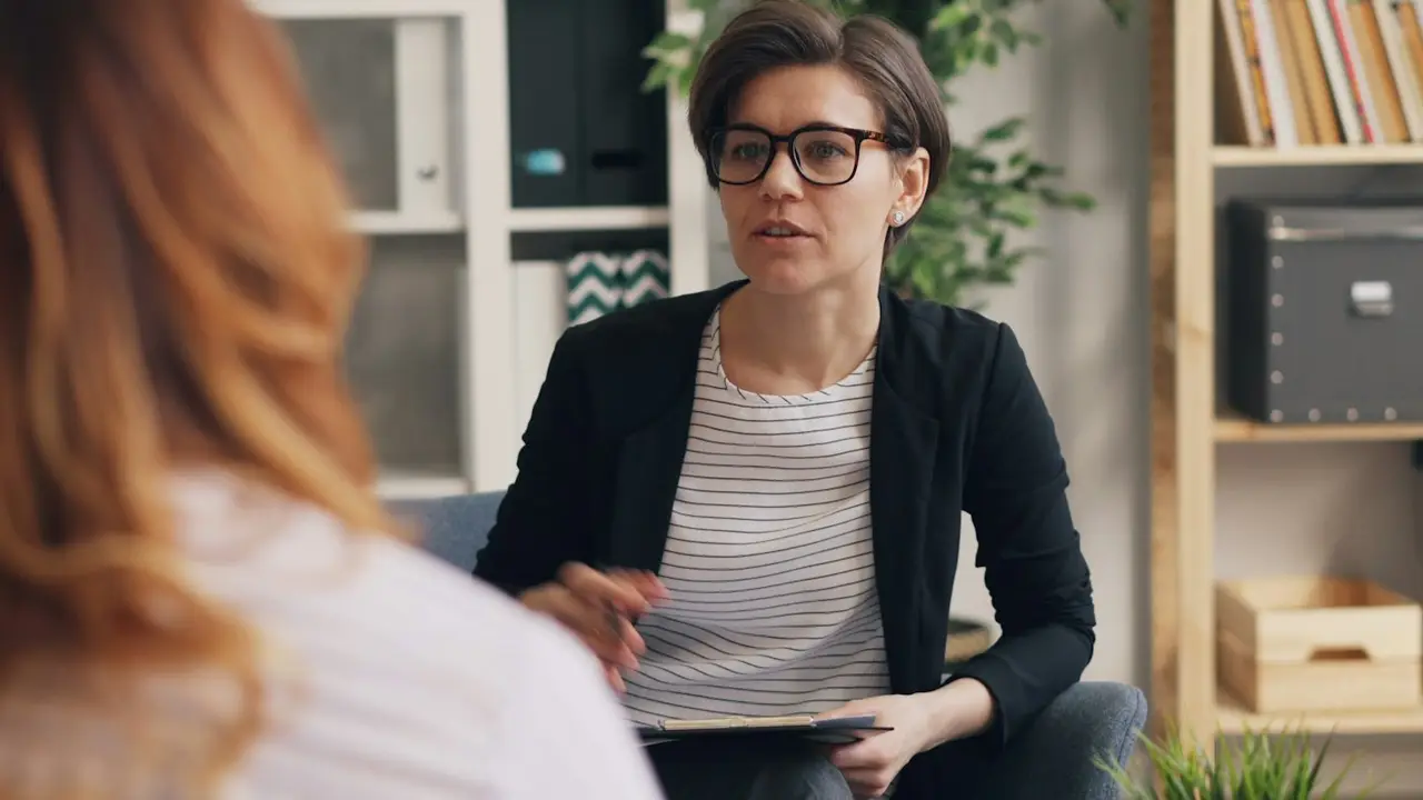Two women talking on a couch in a calm room