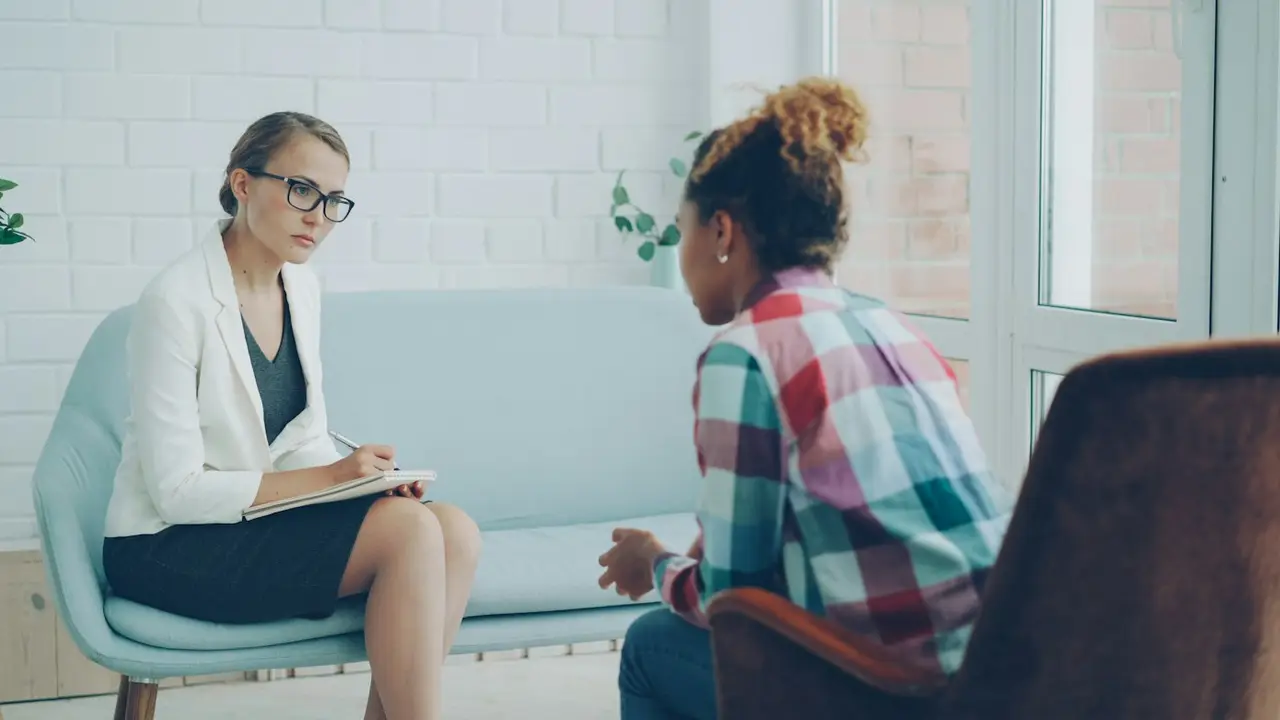 A counselor listening and taking notes in a session