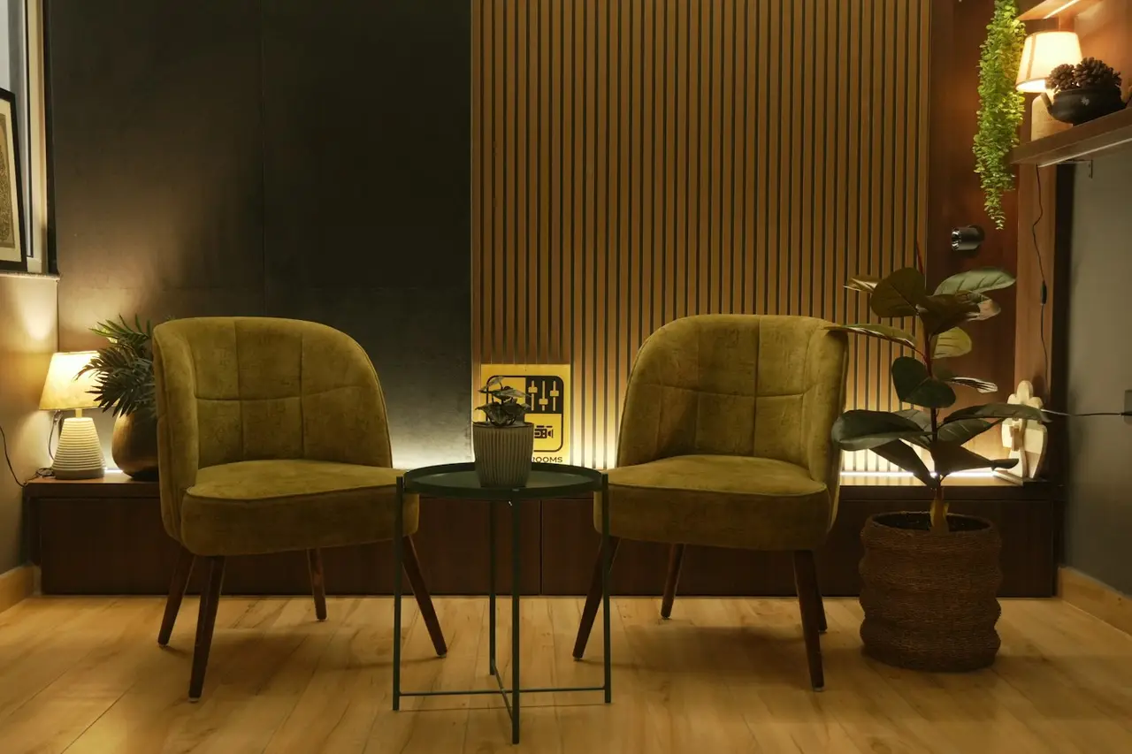 Two green velvet chairs in a quiet, warmly lit room